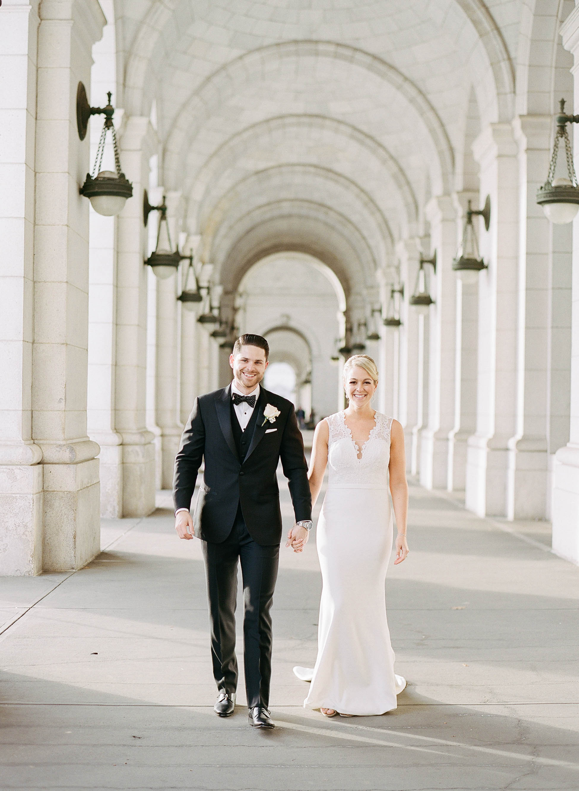 Bride and groom strolling along the facade of Union Station in Washington DC