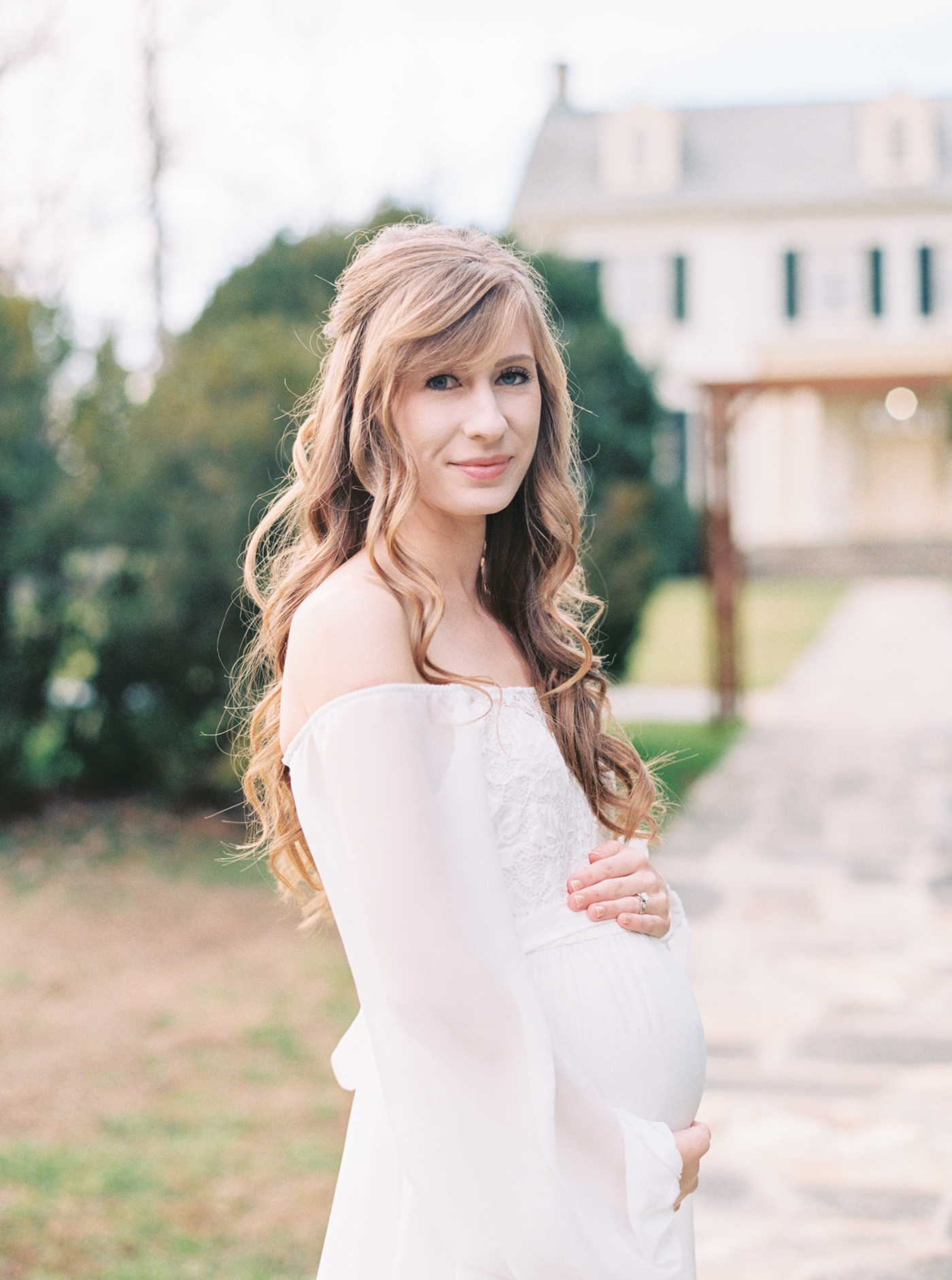 Mom smiling holding her belly at Rust Manor House in Leesburg Virginia for her maternity session