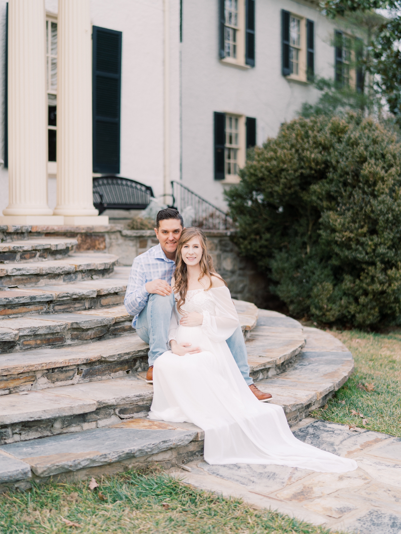 Couples portrait sitting on the stairs at Rust Manor House in Leesburg Virginia for her maternity session