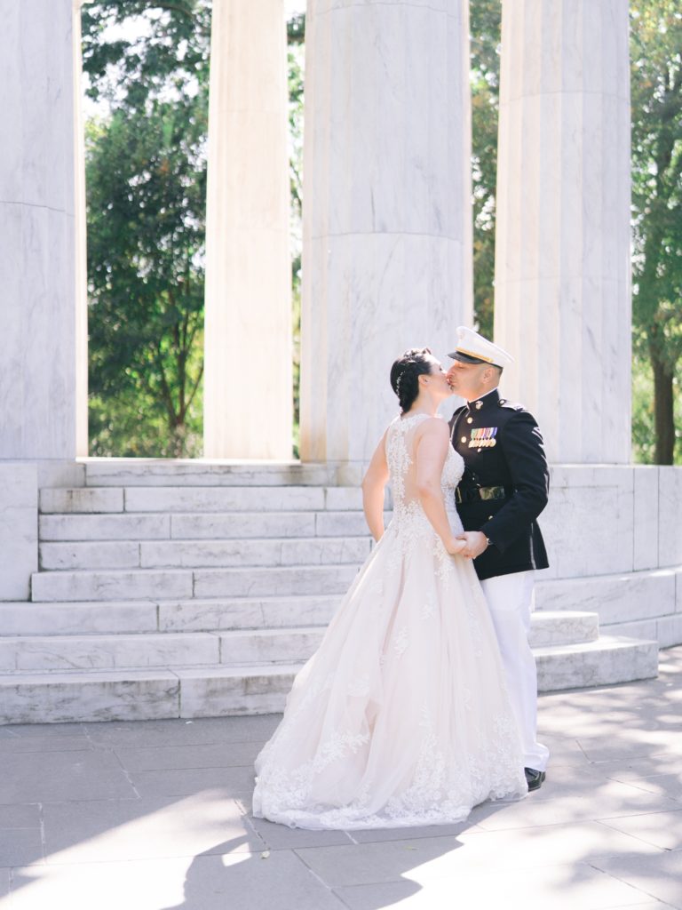bride and groom kiss in front of the war memorial