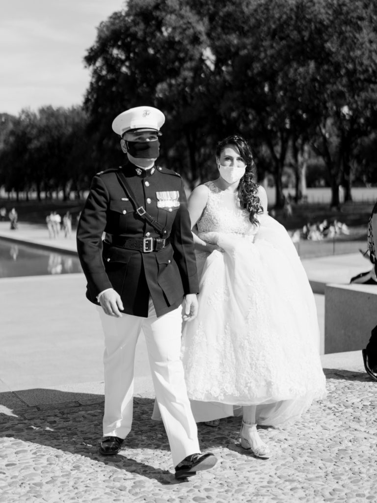 bride and groom in front of the reflecting pool in Washington DC with masks on