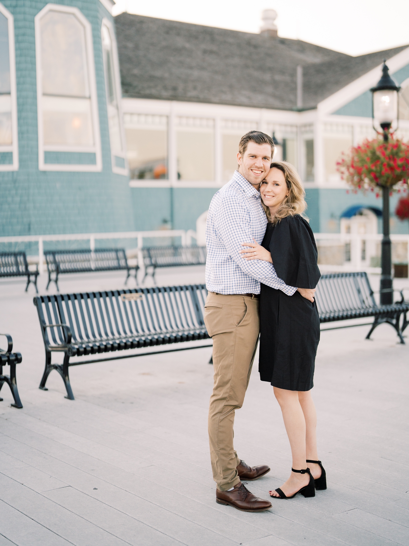 Couple in suit and dress smiles at the camera in old town alexandria waterfront