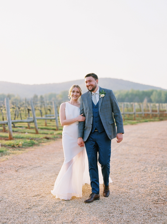 Bride at Groom walking in a vineyard at Keswick Vineyards in Charlottesville VA