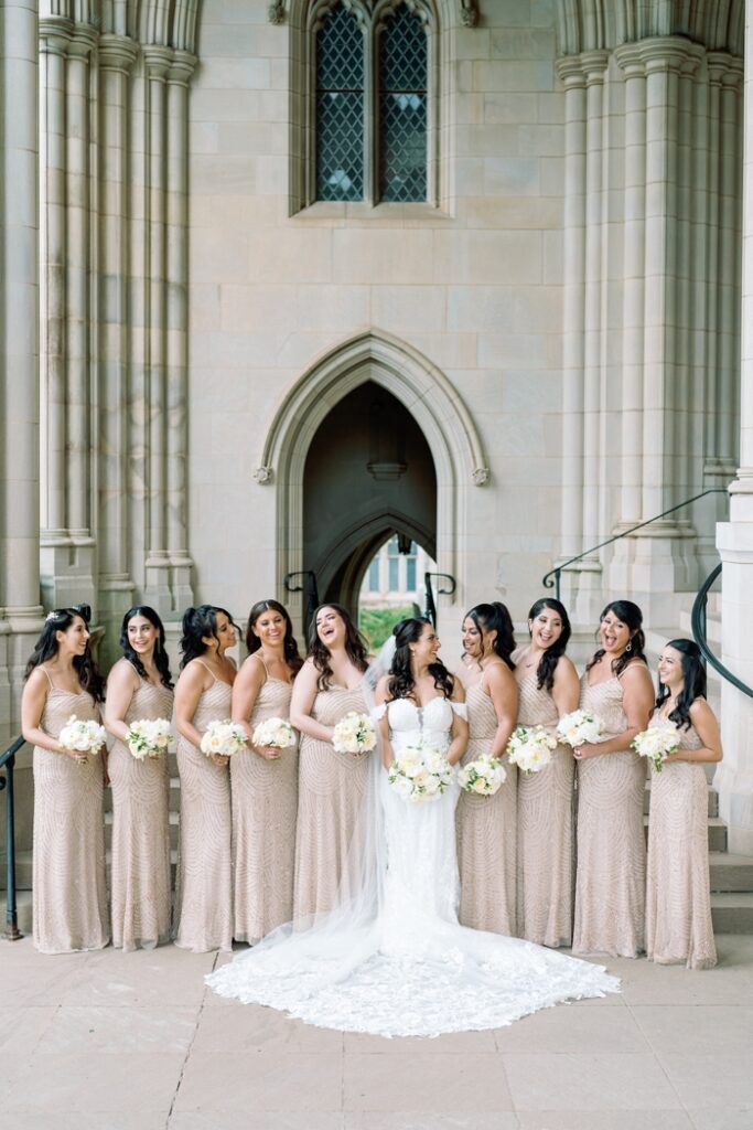 bride and bridesmaids laughing at the national cathedral in washington dc