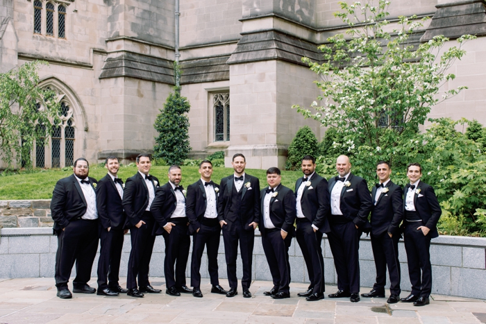 groom and groomsmen smiling at the national cathedral in washington dc