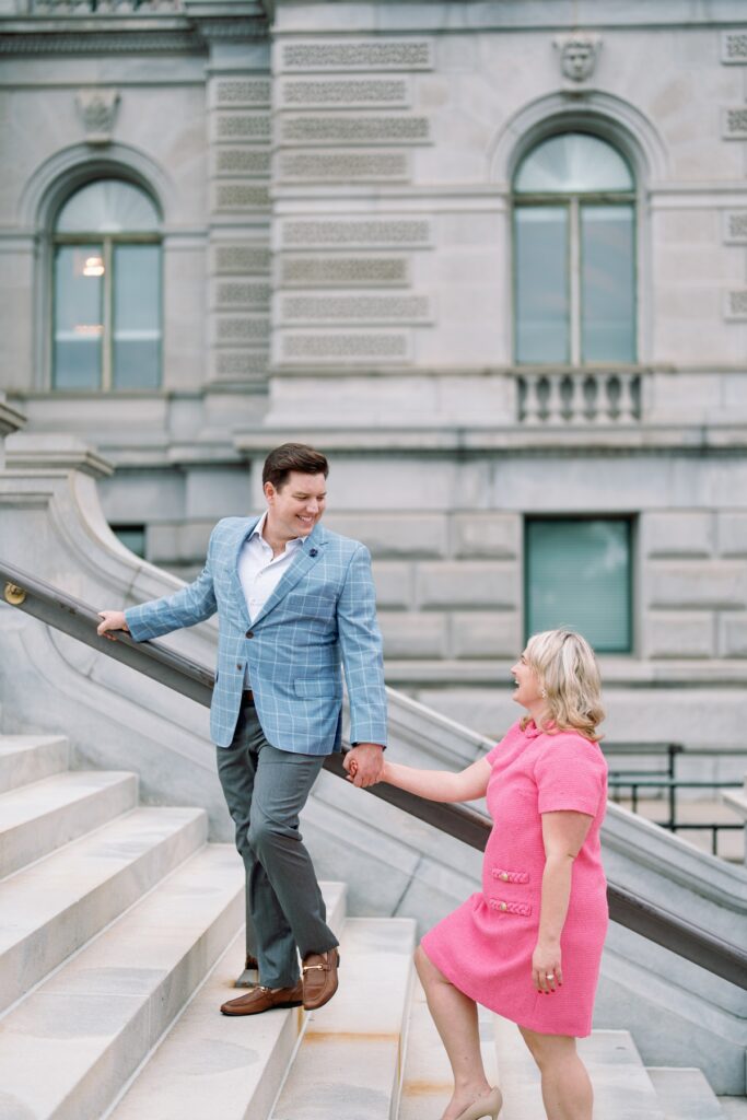 engaged Couple walking up a set of stairs at the library of congress in washington dc