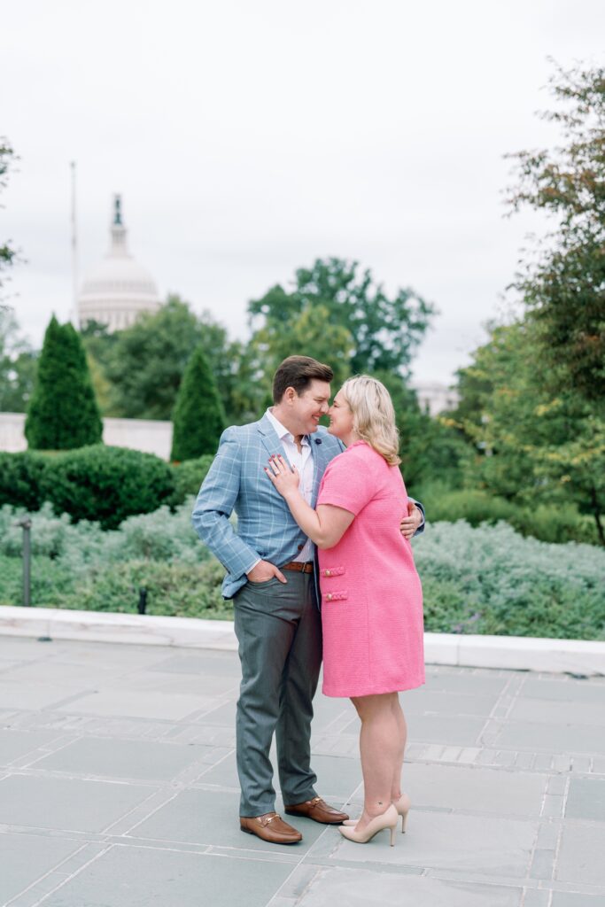 engaged Couple looking at each other with the capitol building in the background in washington dc