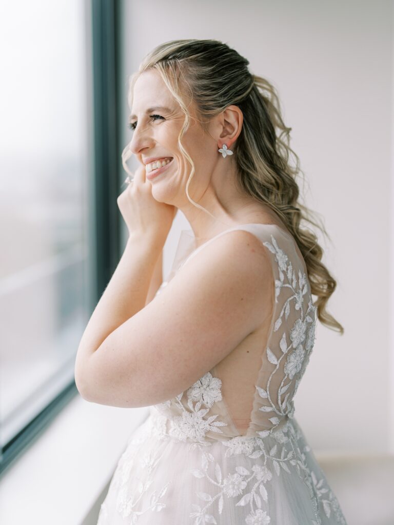 bride putting on earrings at the watergate hotel