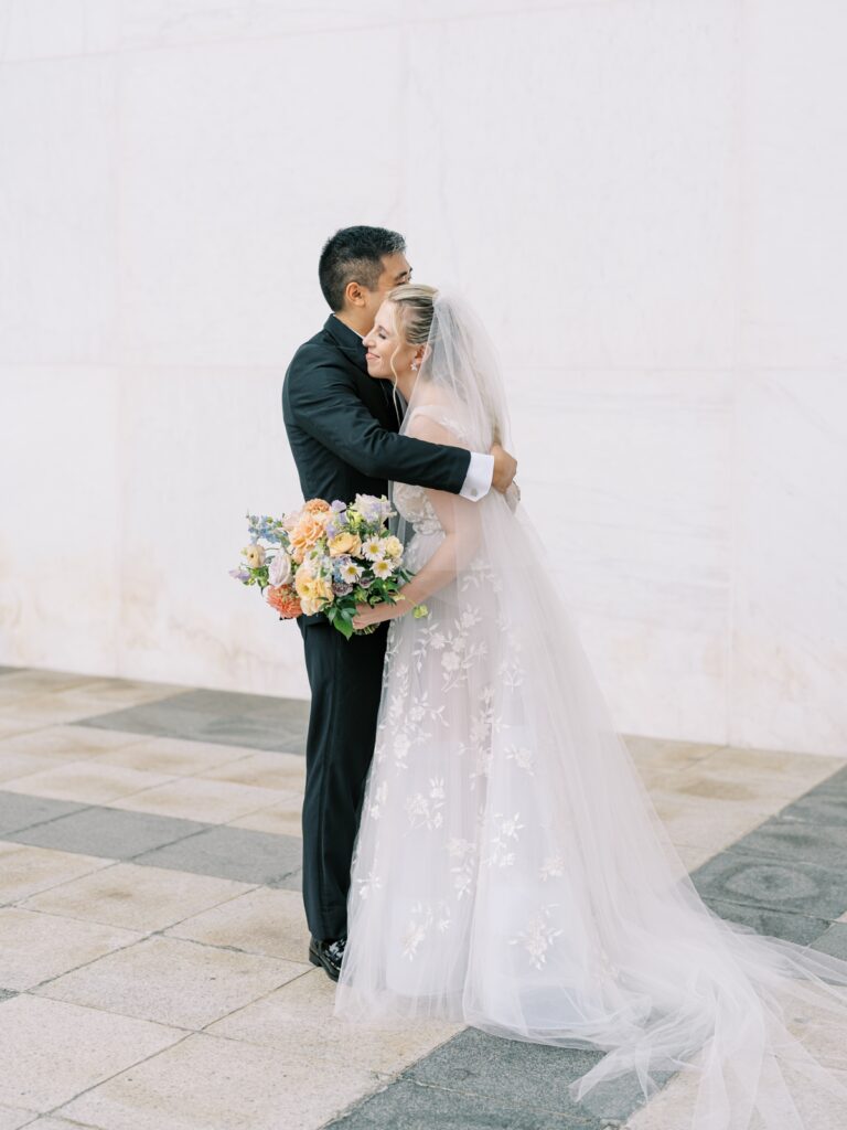bride and groom hug at the kennedy center in washington dc