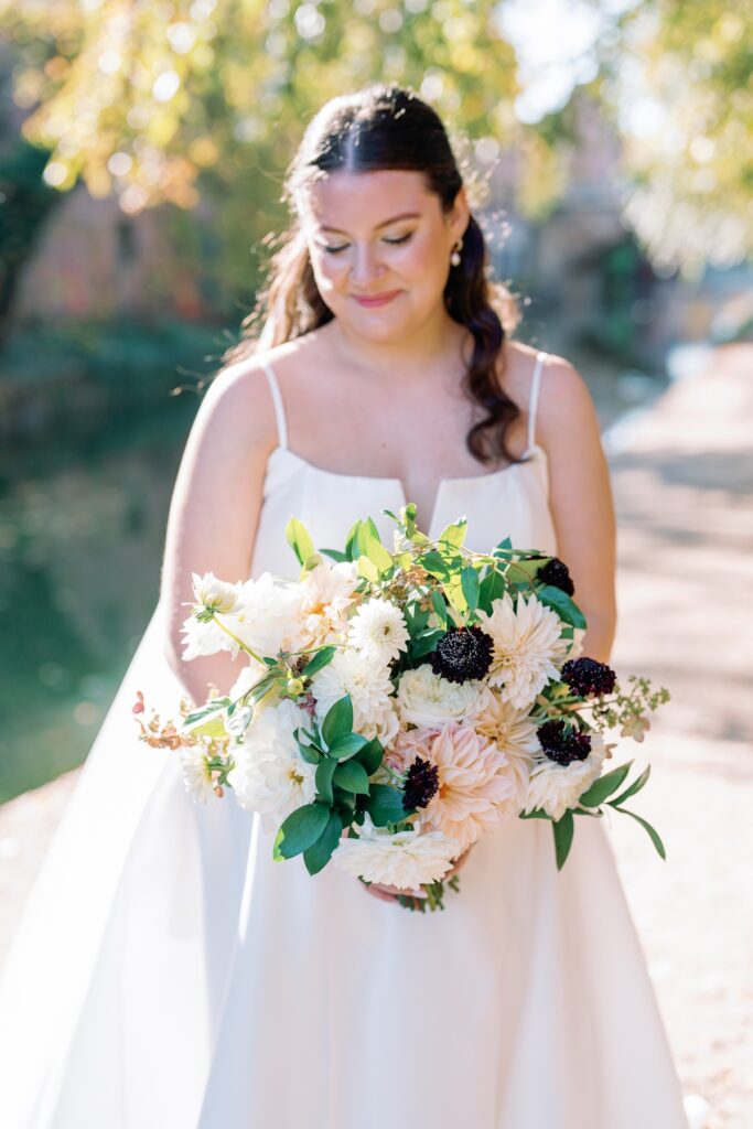 bride smiling down at flowers in georgetown