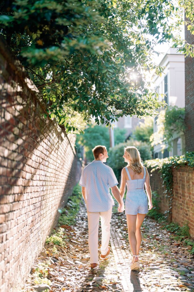 Couple walking away on a cobblestone street in old town alexandria