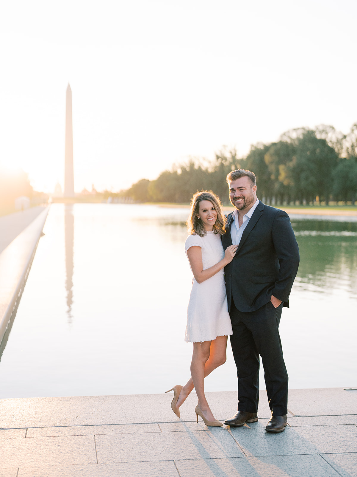 bride and groom smiling at the reflecting pool with the washington monument in the background